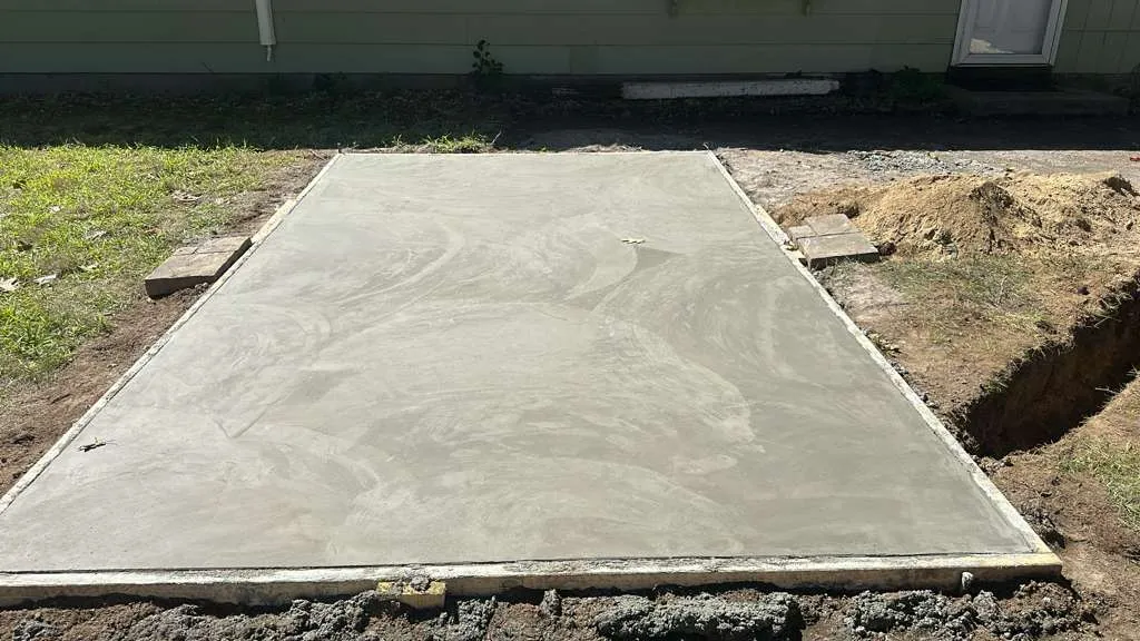 New concrete slab poured and finished by our crew on a compacted base, with the forms still in place